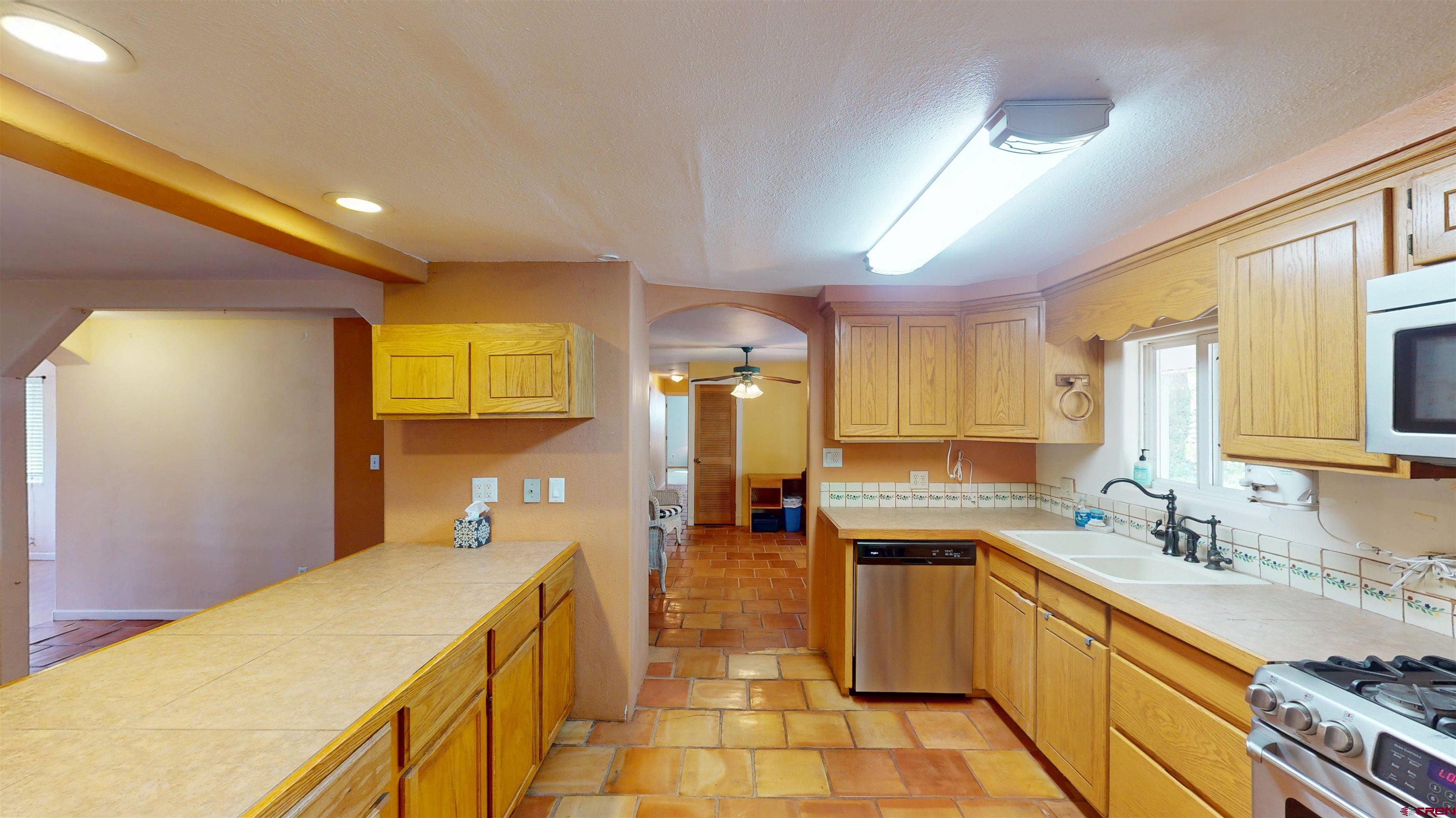 100 Rio Grande Avenue Paonia, CO 81428 - Photo 11 of 45 a kitchen with a sink a counter top space stainless steel appliances and cabinets