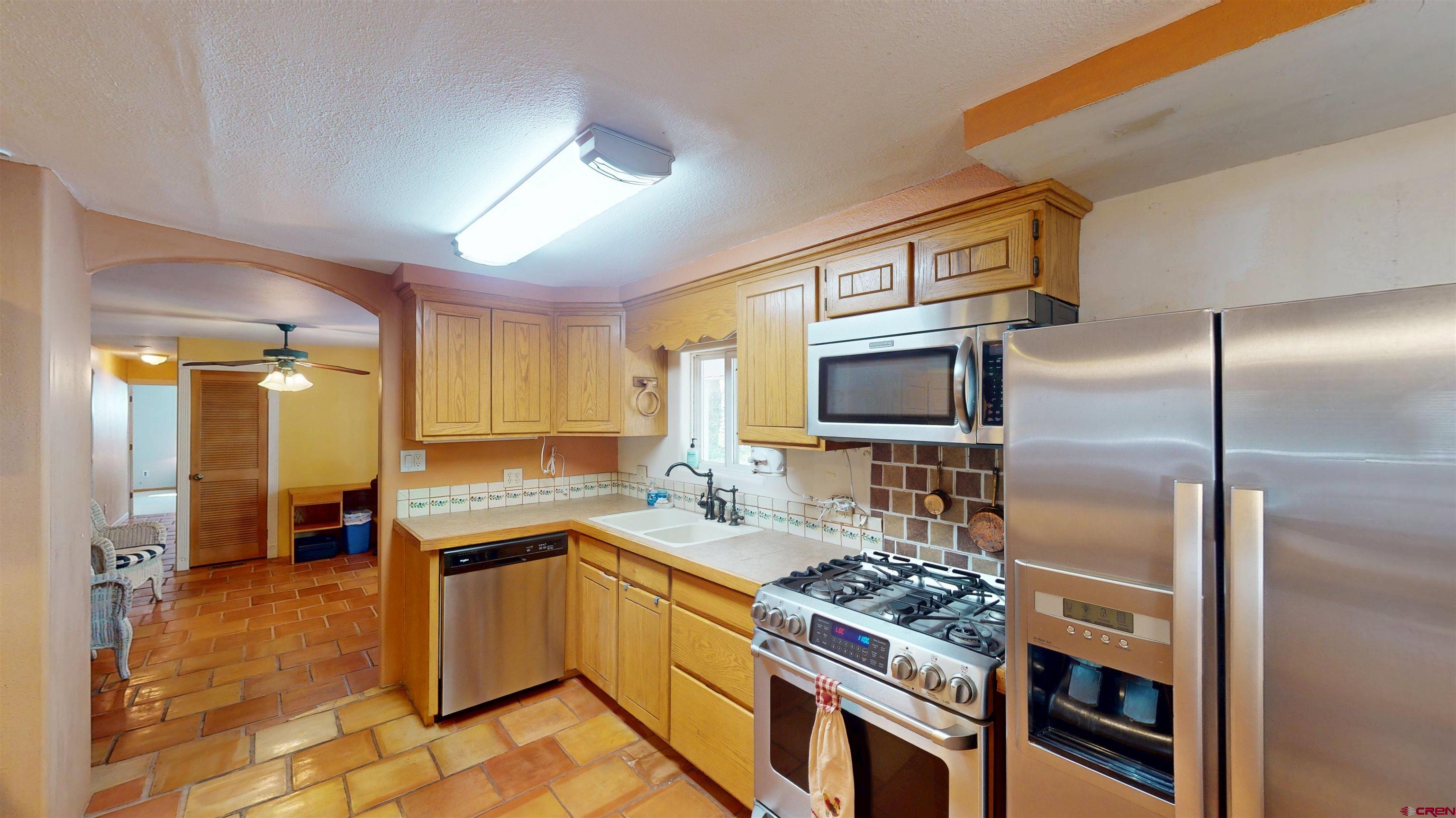 100 Rio Grande Avenue Paonia, CO 81428 - Photo 13 of 45 a kitchen with stainless steel appliances granite countertop a sink stove and refrigerator