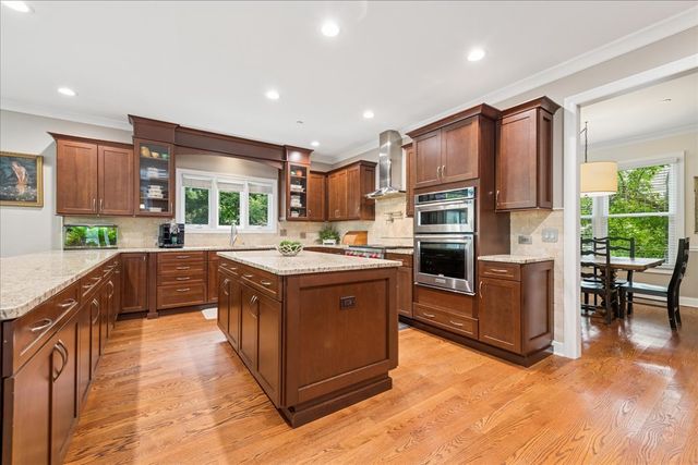 a kitchen with stainless steel appliances granite countertop a refrigerator a stove a sink a oven and a refrigerator