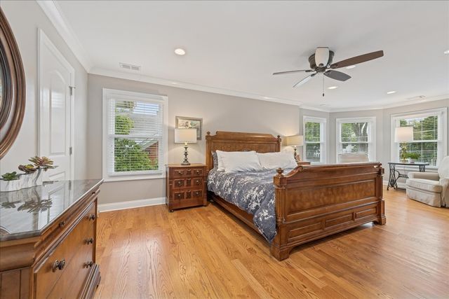 a bedroom with a bed and large windows