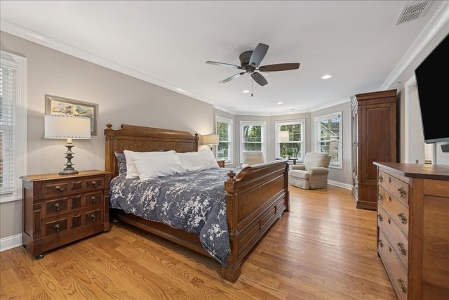 a spacious bedroom with a bed and a flat screen television