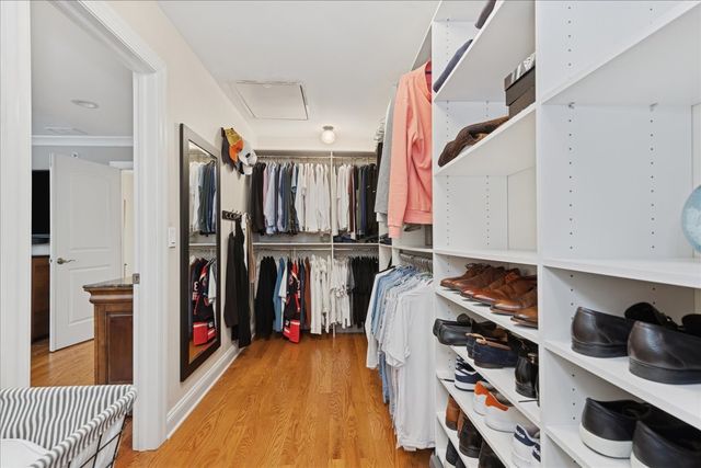 a view of walk in closet with clothes and shoes