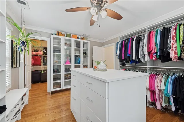 a view of walk in closet with clothes and shoes