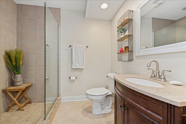 a bathroom with a granite countertop sink a toilet and shower