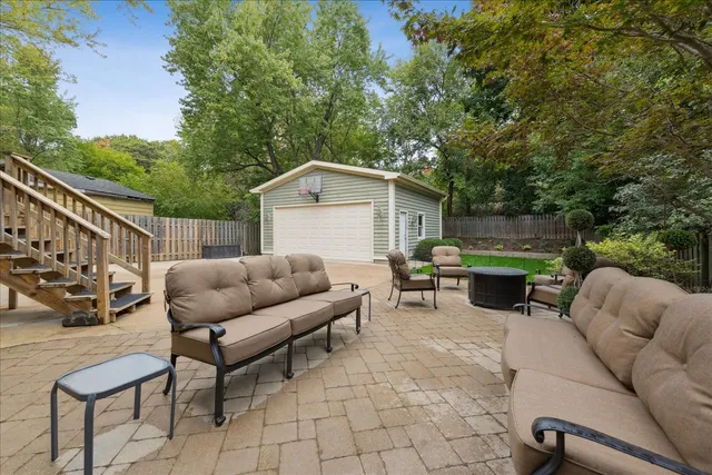 a view of a patio with couches table and chairs with wooden fence