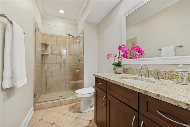 a bathroom with a granite countertop sink a toilet and shower