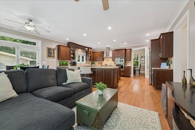 a living room with furniture wooden floor and kitchen view