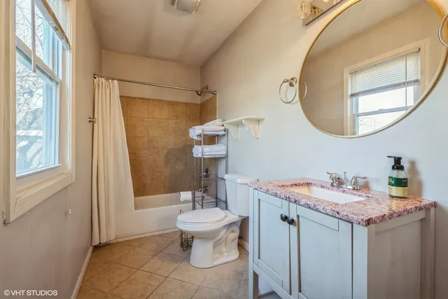a bathroom with a granite countertop sink a toilet and a mirror