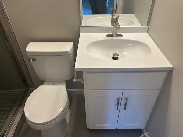 a bathroom with a toilet sink and mirror