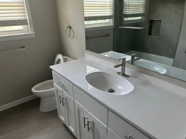 a bathroom with a toilet sink and mirror