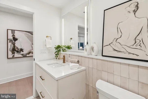 a bathroom with a sink vanity mirror and toilet