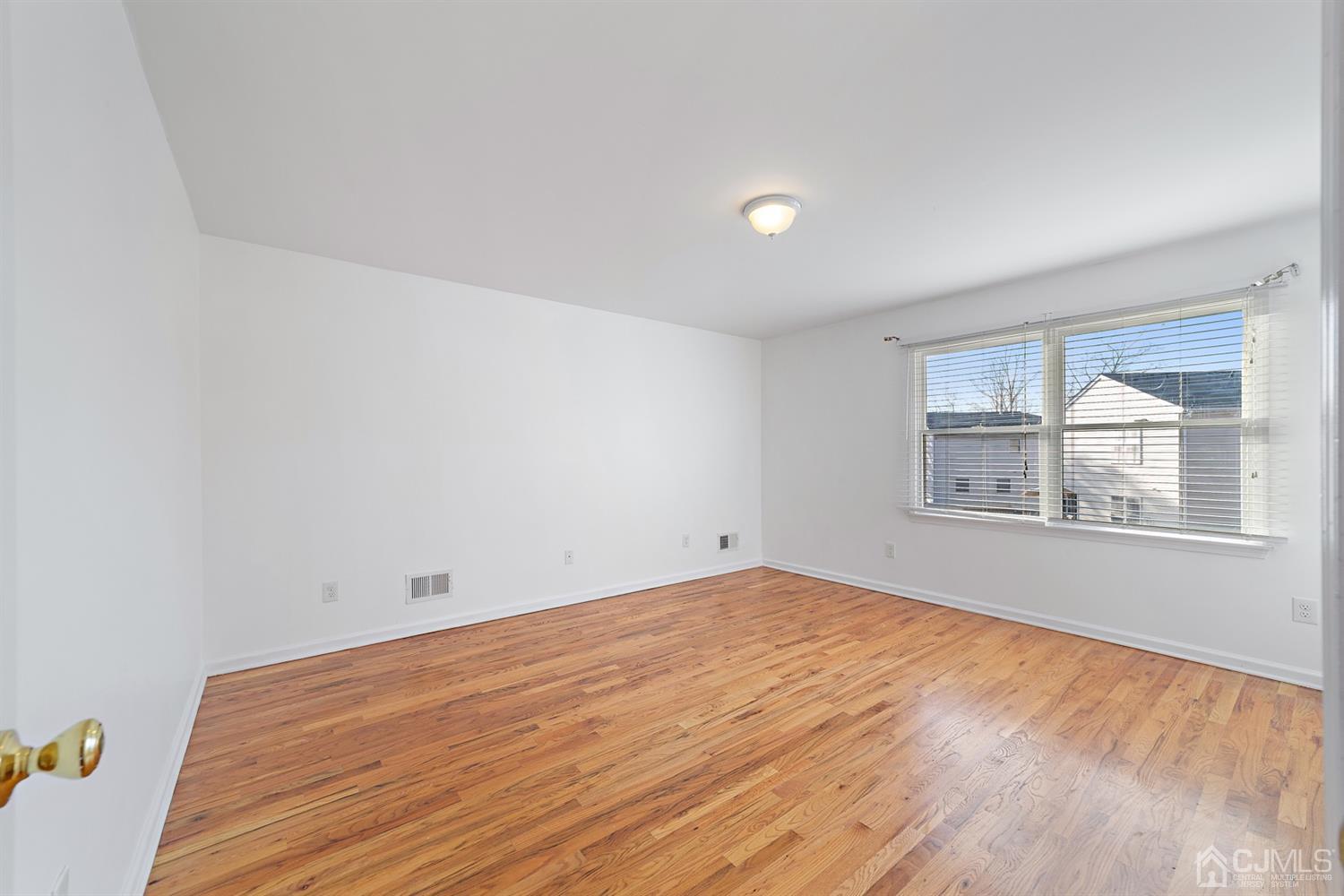 66 Helmetta Road Monroe Township, NJ 08831 - Photo 18 of 25 an empty room with wooden floor and windows