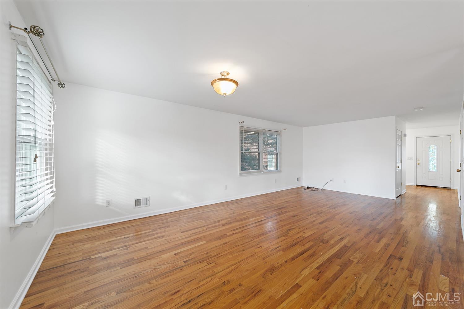 66 Helmetta Road Monroe Township, NJ 08831 - Photo 6 of 25 an empty room with wooden floor and windows