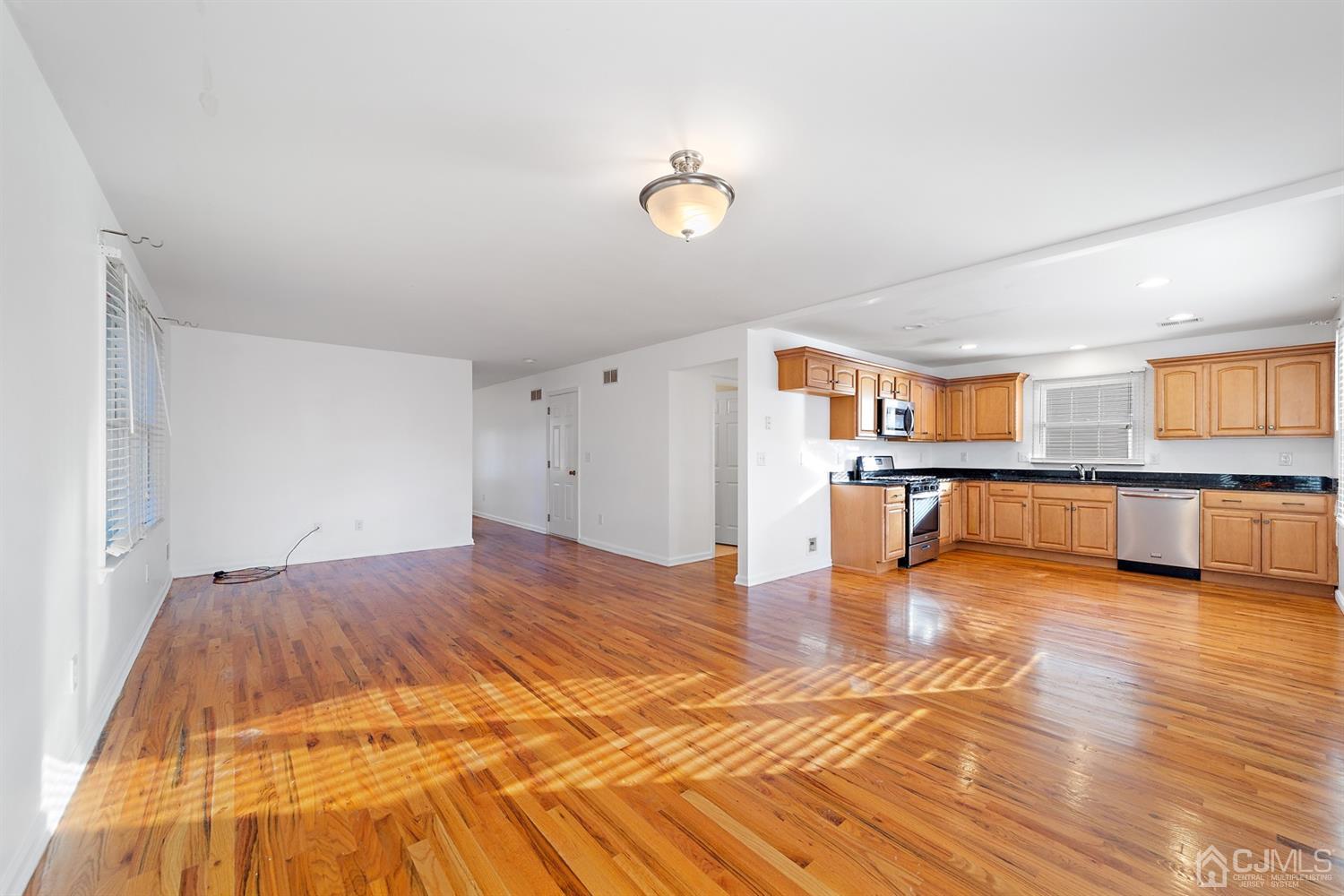 66 Helmetta Road Monroe Township, NJ 08831 - Photo 7 of 25 a big room with wooden floor and kitchen view