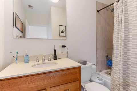 a bathroom with a granite countertop sink and a toilet