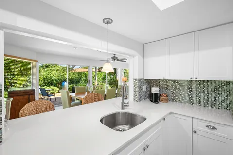 a bathroom with a granite countertop sink vanity mirror and shower
