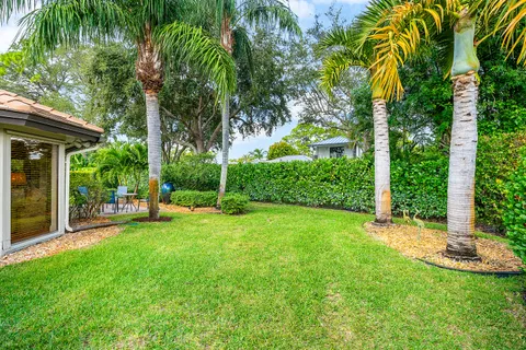 a front view of a house with a yard and palm tree