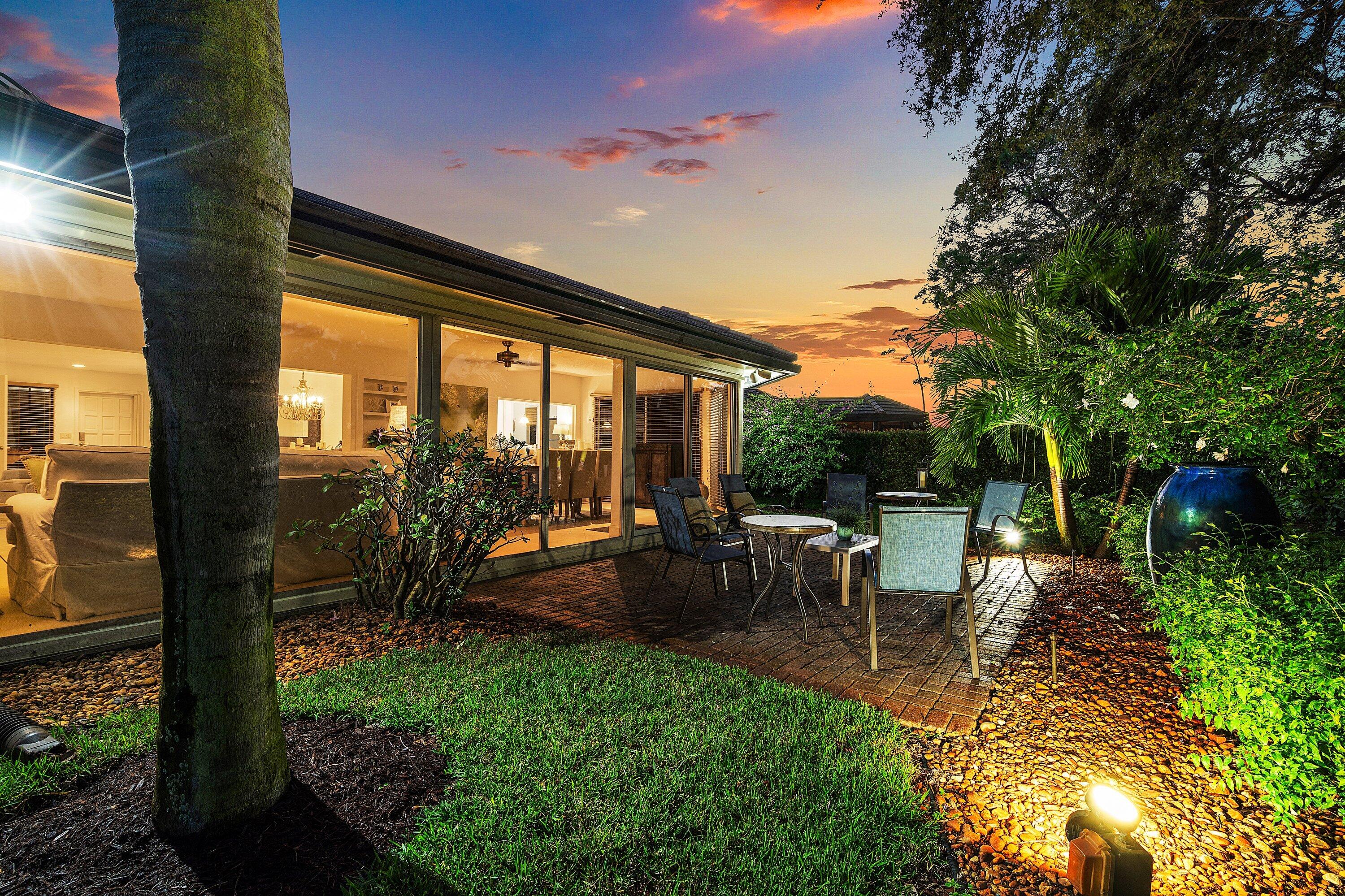 481 Forestview Drive Atlantis, FL 33462 - Photo 65 of 68 a view of a patio with table and chairs potted plants and palm tree
