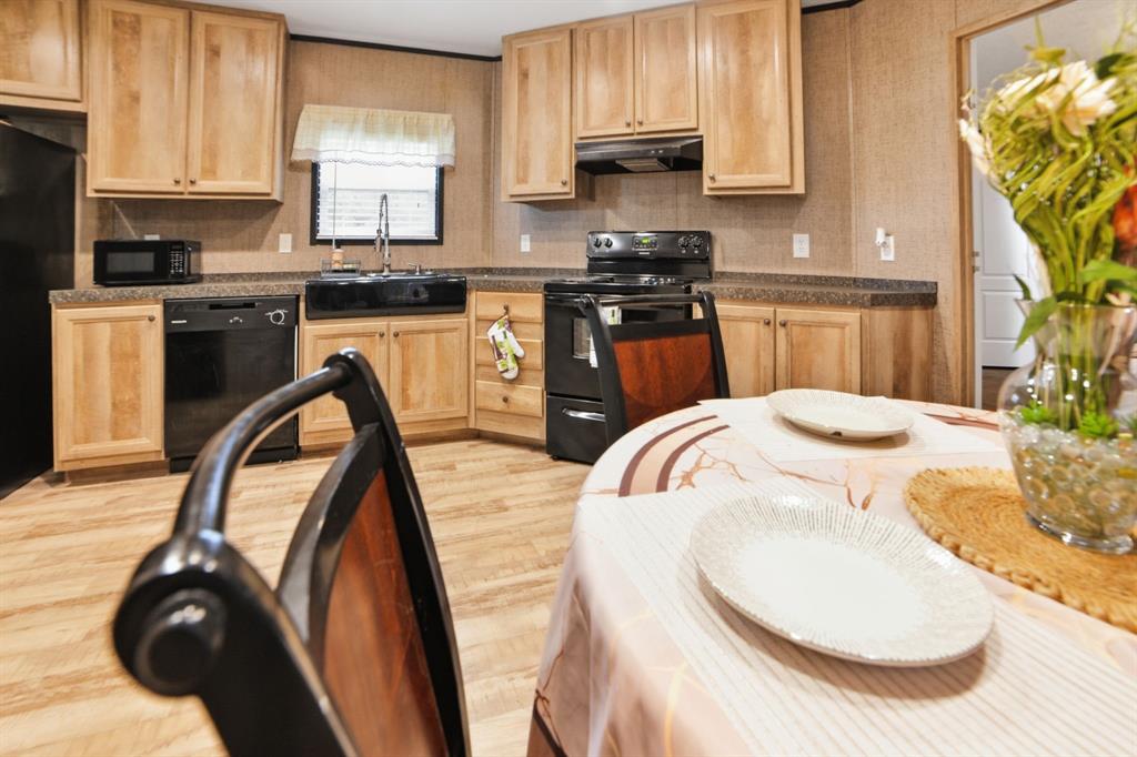 127 Almond Road Minden, LA 71055 - Photo 7 of 25 a kitchen with stainless steel appliances kitchen island granite countertop a sink a stove and a microwave