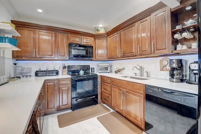 a kitchen with stainless steel appliances granite countertop a sink stove and cabinets