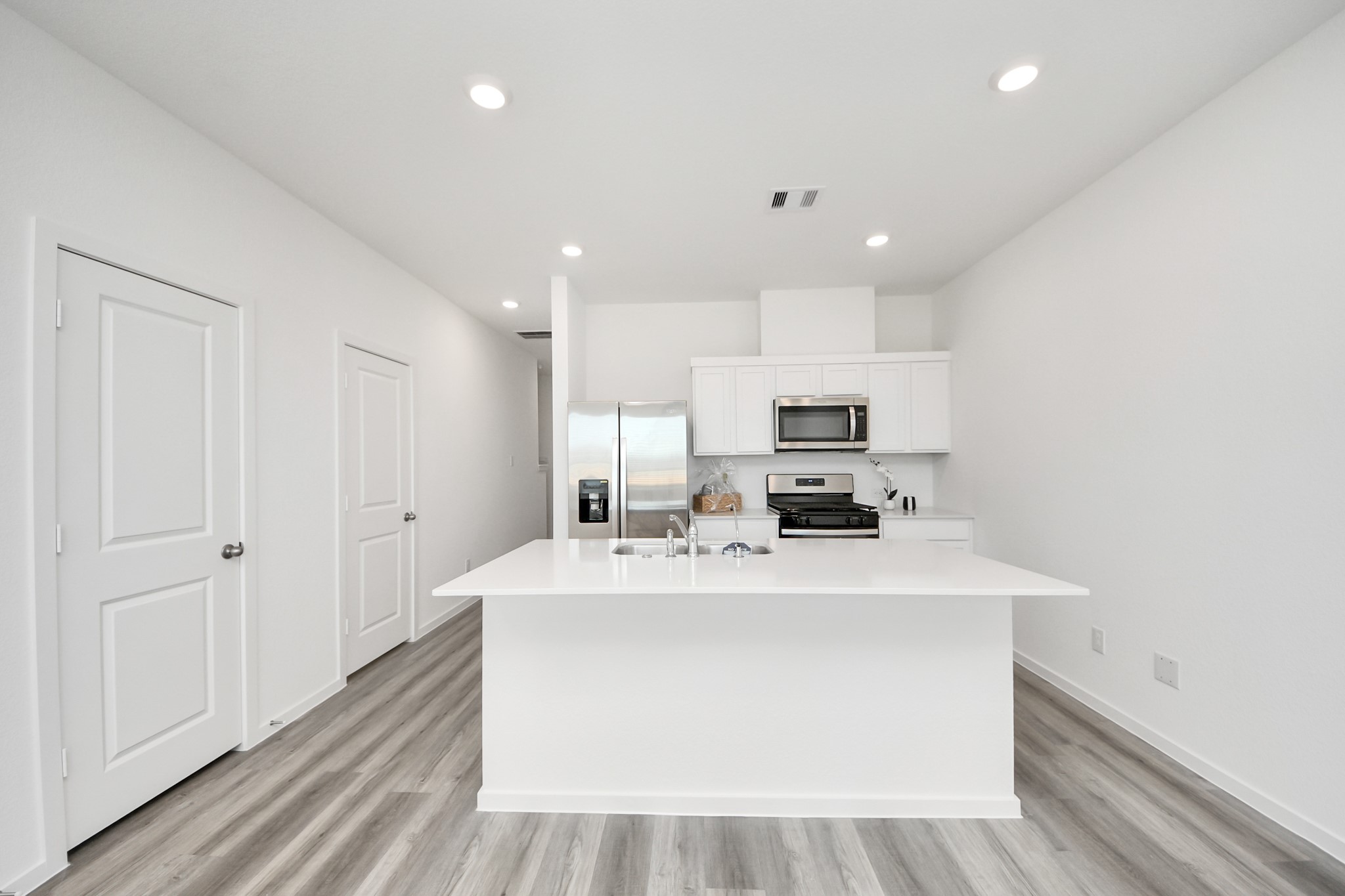 1006 Moon Drop Lane Houston, TX 77090 - Photo 11 of 38 a large white kitchen with kitchen island stainless steel appliances a sink and a counter top