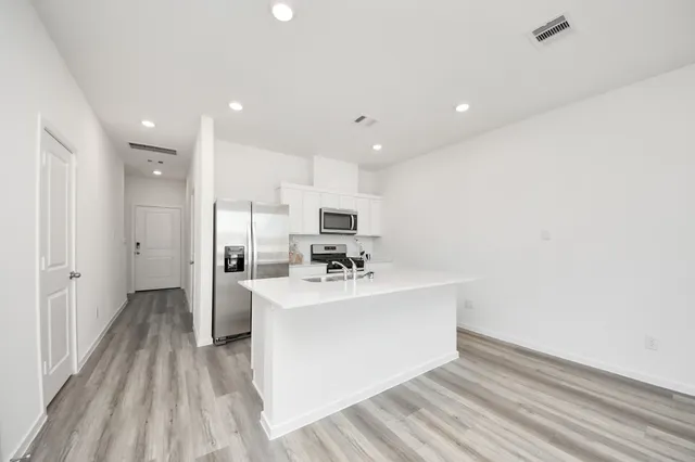 a view of kitchen with sink microwave and refrigerator