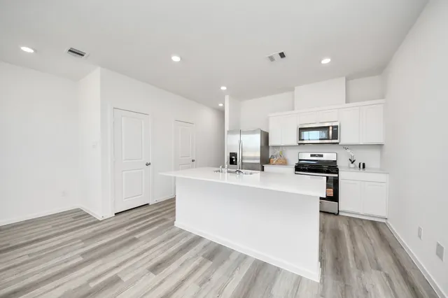 a view of kitchen with sink microwave and refrigerator