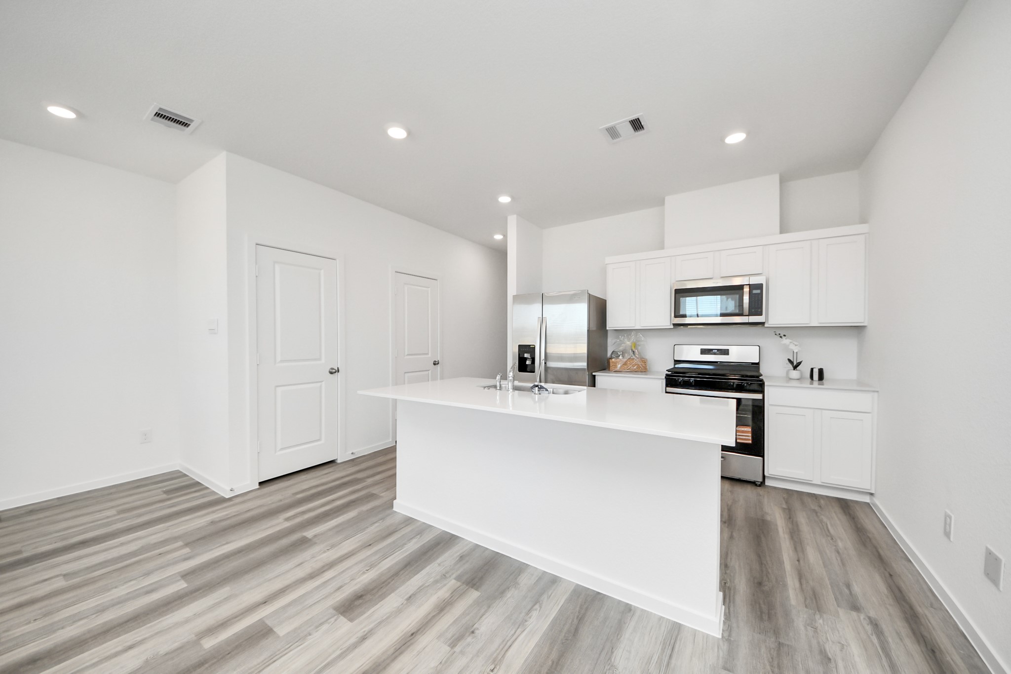 1006 Moon Drop Lane Houston, TX 77090 - Photo 10 of 38 a large white kitchen with cabinets and wooden floor