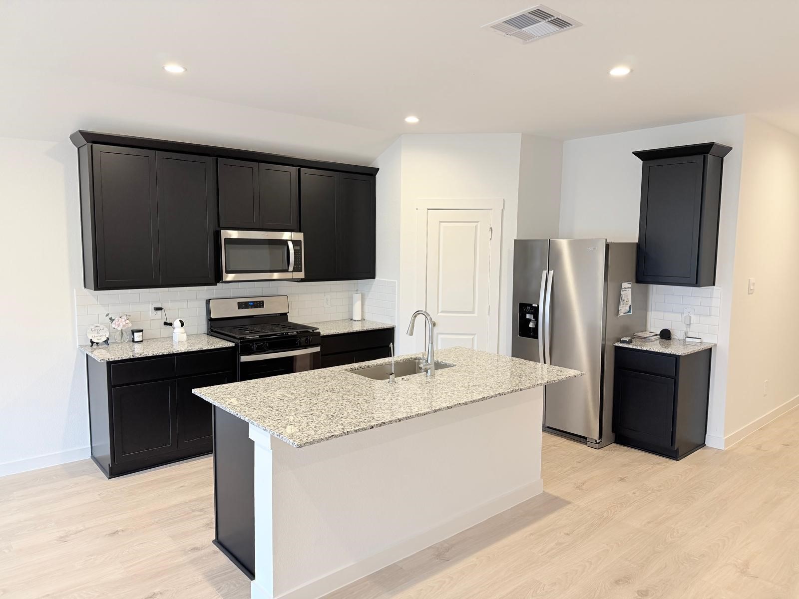 5111 Hunters Trail Fresno, TX 77545 - Photo 4 of 16 a kitchen with a refrigerator stove microwave and sink