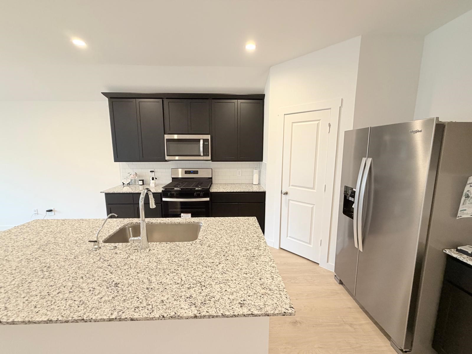 5111 Hunters Trail Fresno, TX 77545 - Photo 8 of 16 a kitchen with granite countertop a refrigerator and a stove top oven
