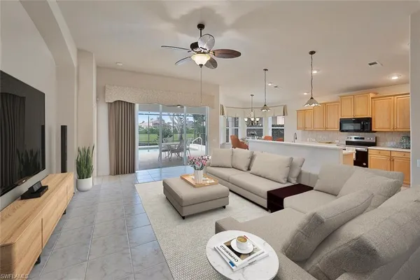 a living room with furniture kitchen view and a flat screen tv