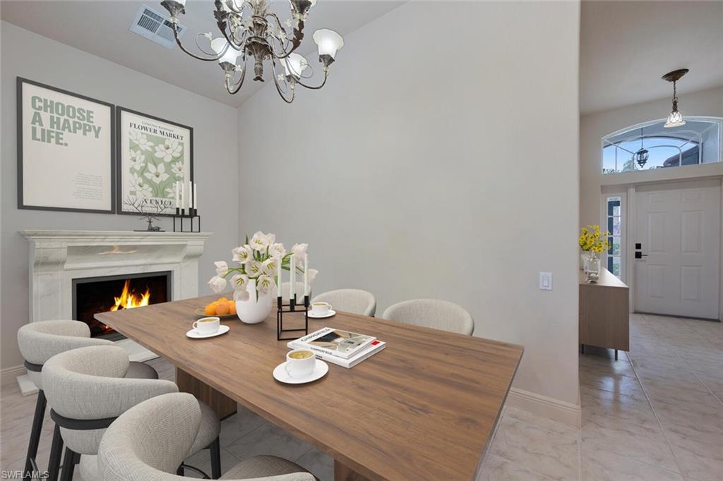 20241 Rookery Drive Estero, FL 33928 - Photo 14 of 33 Virtually Staged Dining area featuring a chandelier, high vaulted ceiling, baseboards, and a premium fireplace