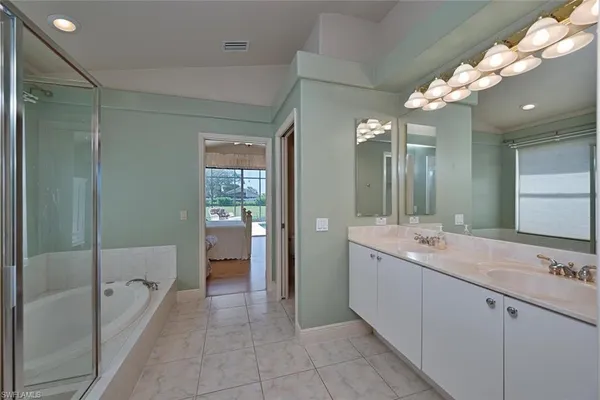 a spacious bathroom with a shower a sink and a mirror