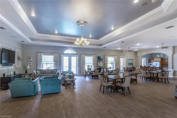 a living room with furniture kitchen view and a large window