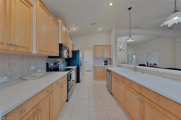 a large kitchen with stainless steel appliances granite countertop a sink a stove and a refrigerator