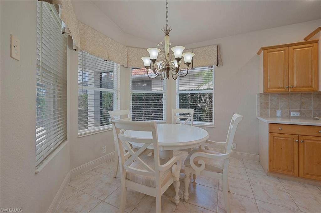 20241 Rookery Drive Estero, FL 33928 - Photo 5 of 33 Dining room featuring light tile patterned floors and a notable chandelier