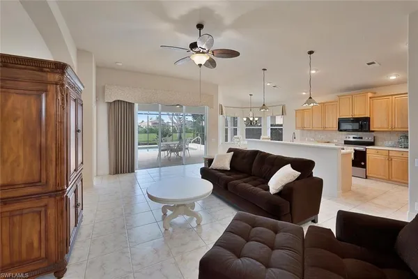 a living room with furniture a ceiling fan and a window