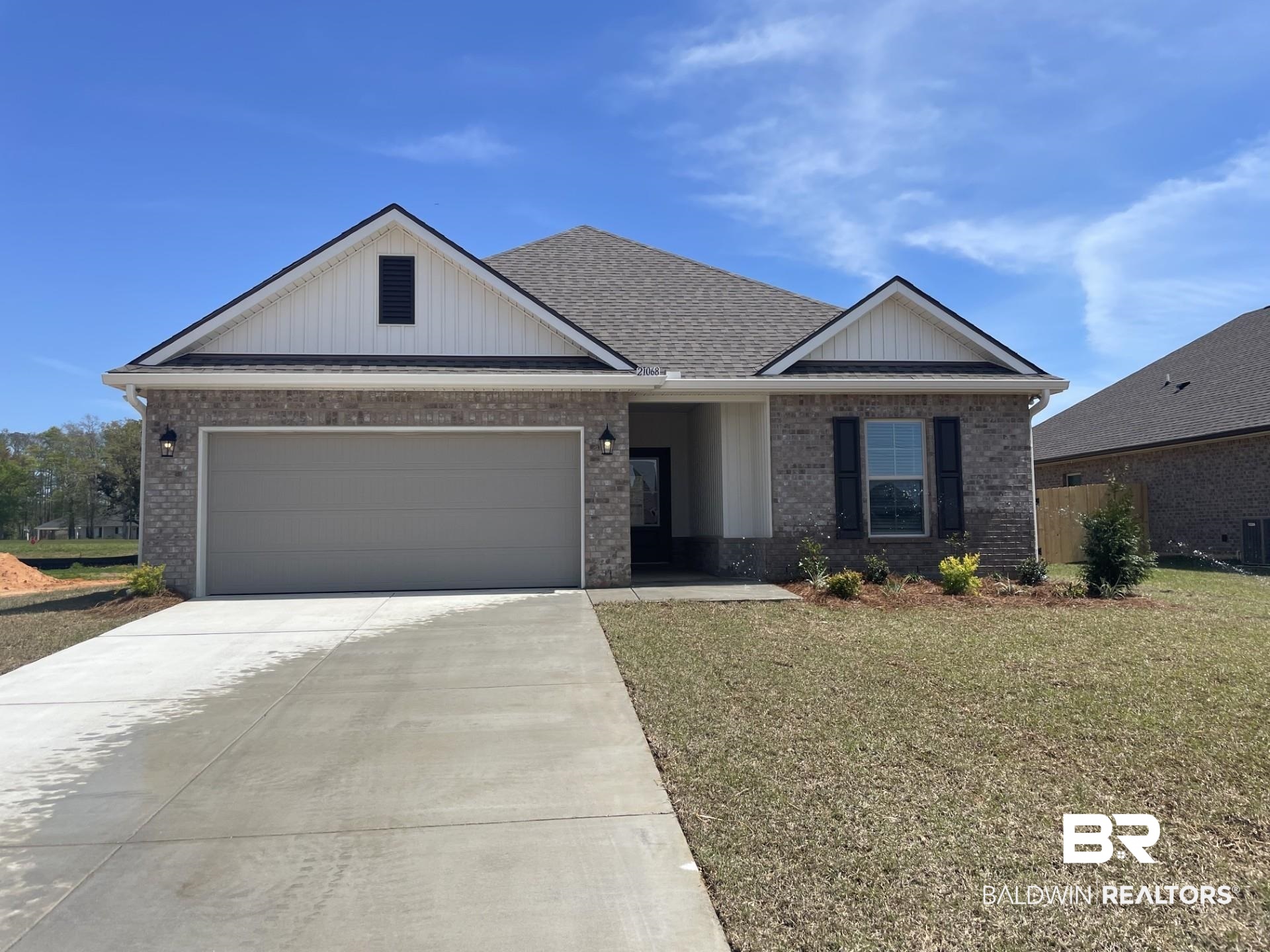 21068 Central Avenue Silverhill, AL 36576 - Photo 1 of 3 View of front of home with driveway, brick siding, a garage, and a front yard