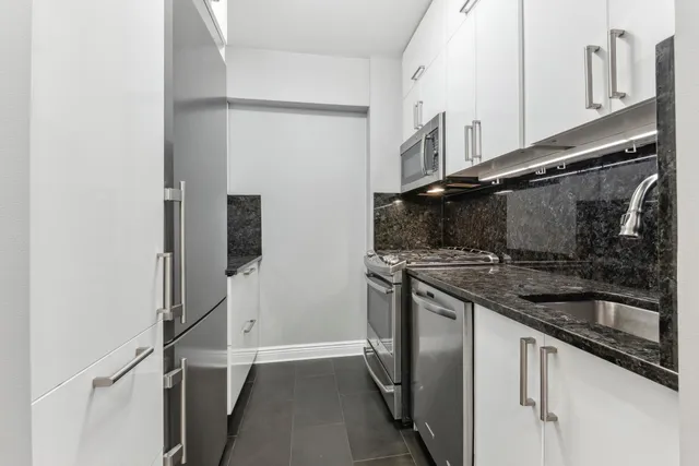 a kitchen with stainless steel appliances granite countertop a refrigerator and a sink
