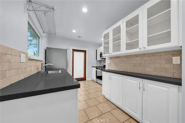a kitchen with granite countertop a sink and a stove