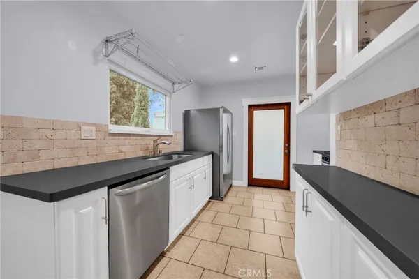 a kitchen with granite countertop a sink and a stove top oven