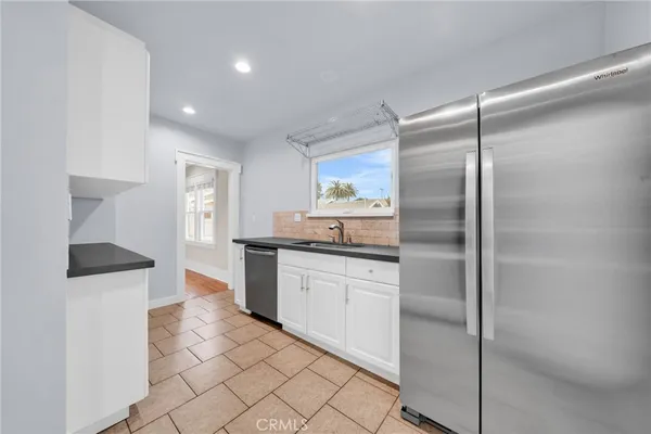 a kitchen with granite countertop a refrigerator and a sink