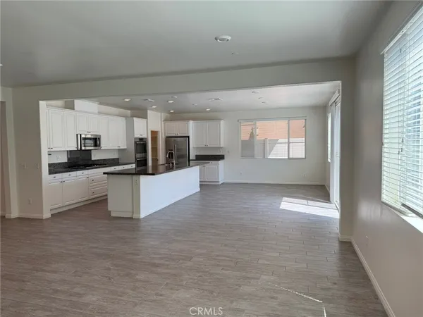 a view of kitchen with granite countertop stainless steel appliances refrigerator sink and cabinets