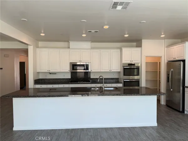a large kitchen with stainless steel appliances and a refrigerator