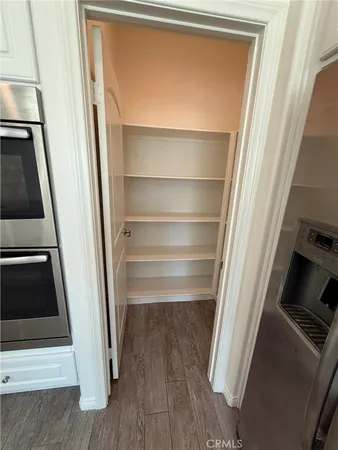 a view of walk in closet with wooden floor and staircase
