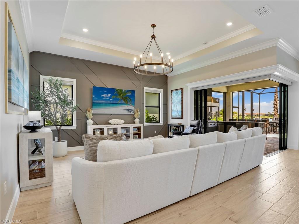 18412 Ridgeline Drive Estero, FL 33928 - Photo 10 of 50 a living room with furniture a chandelier and a flat screen tv