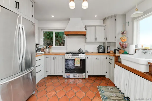 a kitchen with a sink a stove a refrigerator and a window