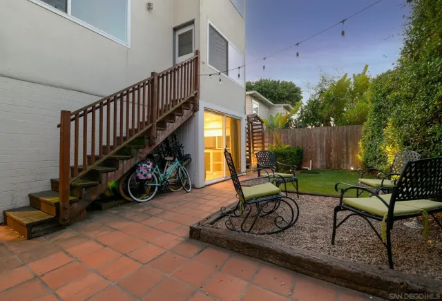 a view of a patio with couches table and chairs and potted plants