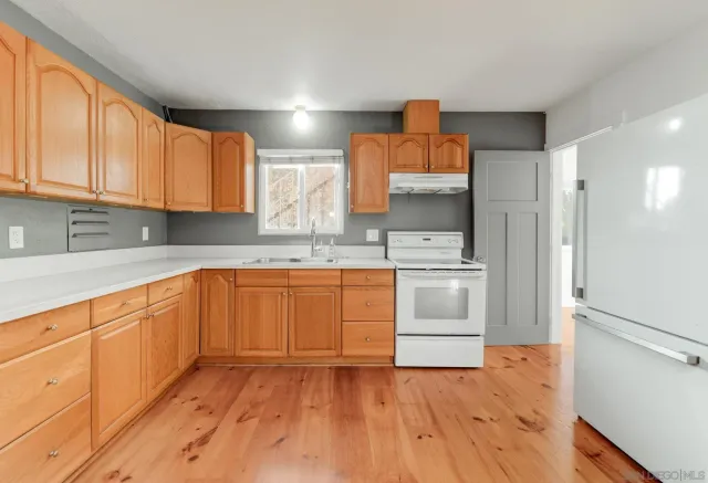 a kitchen with a refrigerator sink and cabinets