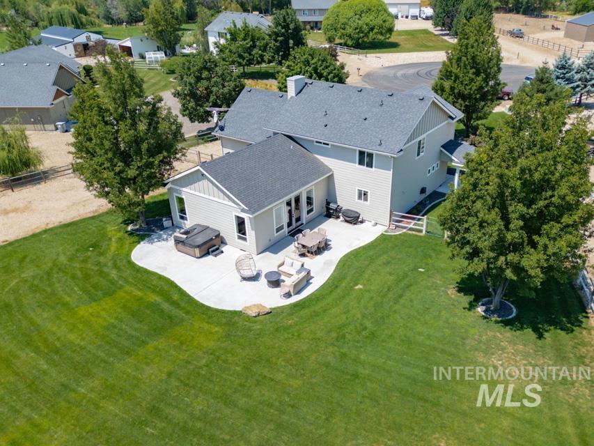 23800 Breyer Road Caldwell, ID 83607 - Photo 37 of 50 Expansive rear yard featuring a large concrete patio, mature trees, and a substantial green lawn